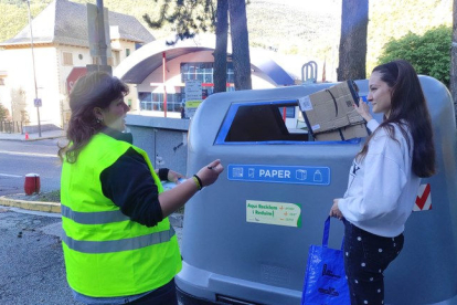 La tècnica, explicant a una usuària els beneficis del reciclatge.