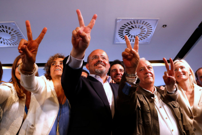 El candidat del PP català, Alejandro Fernández, gesticula el senyal de la victòria amb altres càrrecs.