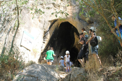Un grup d’adults i nens, abans d’entrar a la Cova dels Muricecs després de reobrir al març.