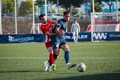 Peke disputant una pilota amb un jugador del Vic.