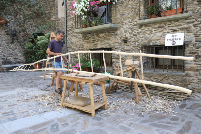 Pep Aymerich creant una escultura de fusta, un dels tallers artístics als carrers de Llavorsí.