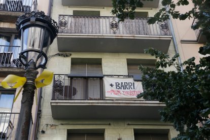 La pancarta '+ barri - pisos turístics' en un balcó de la Rambla de Girona