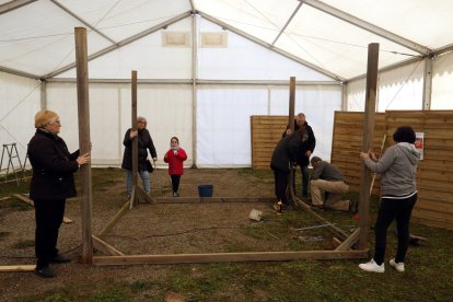 Veïns voluntaris enllesteixen una estructura de fusta del pessebre vivent del barri dels Mangraners de Lleida.