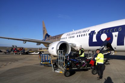 Personal descarregant esquís d'un avió de Polish Airlines a l'aeroport de Lleida-Alguaire