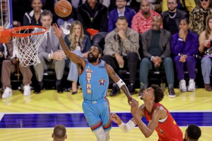 Kyrie Irving intenta anotar davant de Victor Wembanyama. - EFE