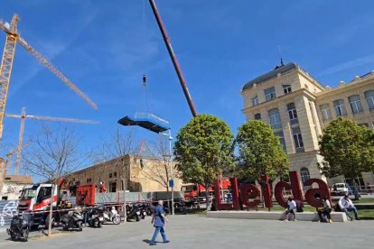 Una gran grua retira les escales del pas elevat de l'estació de tren de Lleida