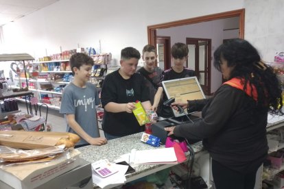 Uns adolescents comprant diversos productes ahir a la botiga reoberta al Soleràs. - J.M.