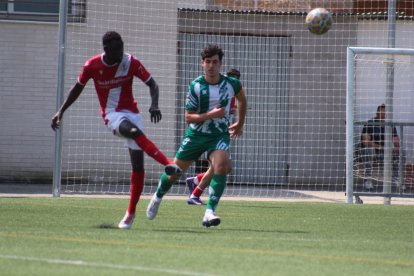 Un jugador de l’Artesa de Segre rebutja la pilota davant de la presència d’un jugador rival. - JOAN BOVÉ
