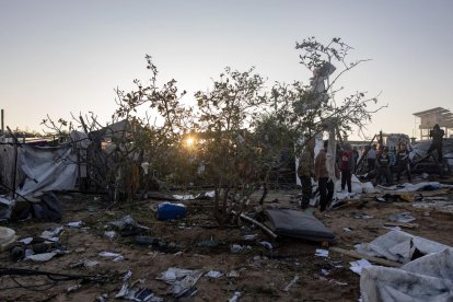 Palestins inspeccionant els danys després d’un atac aeri israelià dirigit a un campament de persones desplaçades. - EFE/EPA/HAITHAM IMAD