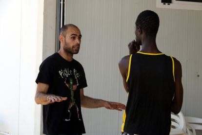 Daniel Delgado, treballador social de l'alberg de Seròs, enraona amb un dels usuaris de l'equipament.