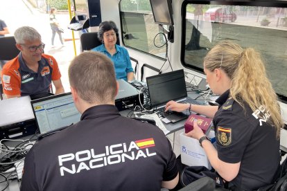 Dos ciutadans tramiten els seus documents a la nova unitat mòbil a Oliana. - ALBERT L. COBO/ACN