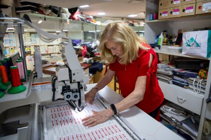 Marina Monsó treballant, amb una màquina brodadora al taller.