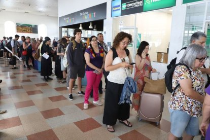 Cua de passatgers per reclamar a l’oficina de Renfe a l’estació de Lleida. - S COSTA D