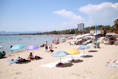 Turistes i banyistes prenent el sol i banyant-se a la platja de Salou