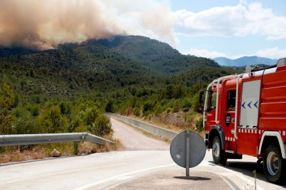 Un camió dels Bombers davant les flames. - ACN