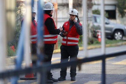 Treballadors custodiant l’accés a les oficines de la mina. - ELVIS GONZÁLEZ/EFE