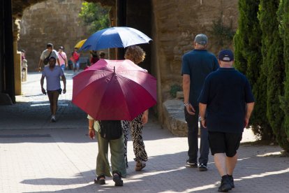 Persones amb parasol pel Turó de la Seu Vella de Lleida.