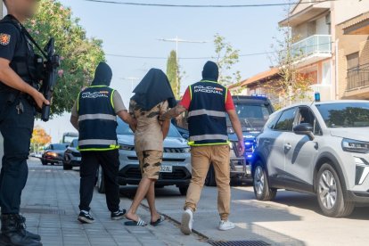 El moment en què el detingut és portat a un cotxe policial. - PAU PASCUAL