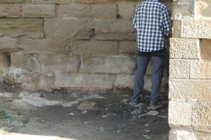 Un home fa les seves necessitats a l'antiga muralla de Lleida