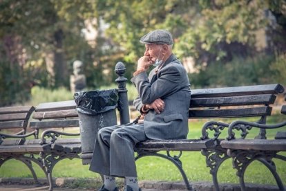 Fotografia d'un padrí assentat en un banc.