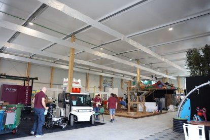 Operaris muntant els estands que acollirà durant 3 dies el nou pavelló de Fira de Lleida. - AMADO FORROLLA