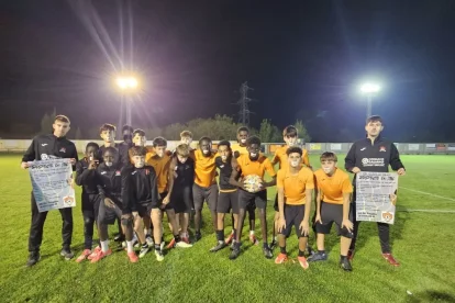 Jugadors de l’EF Pinyana ahir amb els adhesius a la boca i els seus tècnics, amb els cartells al·lusius.