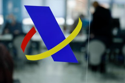 Logotipo de la Agencia Tributaria en una mampara de una oficina.