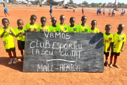 Nens del Centre Djiguiya de Bamako, a Mali, mostren una pancarta de suport al Club Esportiu Ciutat la Seu.