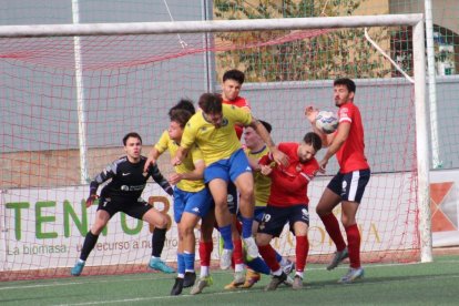 Diversos jugadors dels dos equips pugnen per arribar a la pilota. - JOAN BOVÉ
