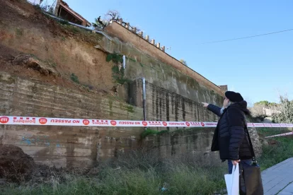 Un veí mira el mur de contenció que va caure a Balaguer. - AMADO FORROLLA