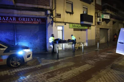 Personal de la funerària, ahir a la nit mentre traslladaven el cos de la víctima des d’un pis del carrer Ciutat de Fraga. - AMADO FORROLLA