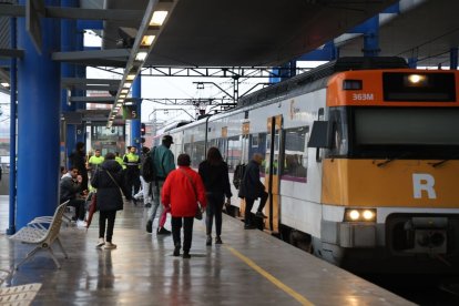 Passatgers pugen a un comboi de Rodalies a l’estació de Lleida-Pirineus. - AMADO FORROLLA