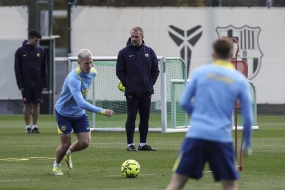 Hansi Flick, ahir observant l’entrenament amb Dani Olmo intentant colpejar la pilota. - EUROPA PRESS