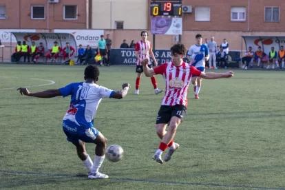 Un jugador del Guissona busca desplaçar la pilota davant la pressió d’un jugador de l’Agramunt. - LAIA PEDRÓS
