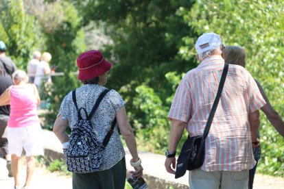 Un home i una dona passegen amb gorres durant l'onada de calor