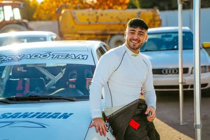 Nicolás Garriga al costat del cotxe de competició que pilota.