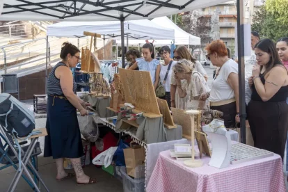 Clients s’interessen pels articles d’una parada del Mercat de le Rebaixes de la Zona Alta, a la plaça Ricard Viñes. - PAU PASCUAL PRAT