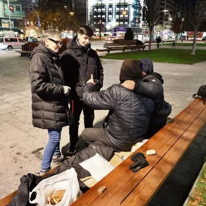 L’Eric i la Mònica, educadors socials, conversen amb dos persones sense llar que ajuden al costat de l’estació de trens. - AMADO FORROLLA