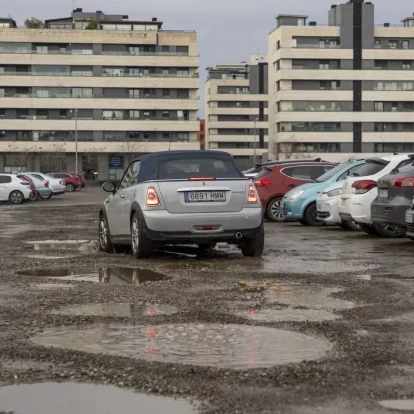Un cotxe circulant pel solar que funciona com a pàrquing darrere del col·legi Frederic Godàs. - JORDI ECHEVARRIA
