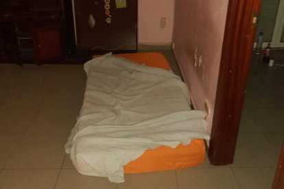 Un individu escalant per la façana i, a l’interior del pis, un matalàs, roba i begudes.