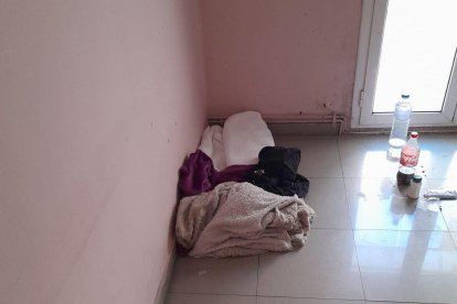 Un individu escalant per la façana i, a l’interior del pis, un matalàs, roba i begudes.