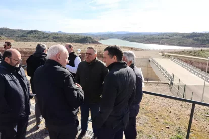 El conseller va recórrer les instal·lacions de la presa amb els responsables de la infraestructura. A la dreta, el desaigüe de fons alliberant el cabal ecològic al riu. - AMADO FORROLLA
