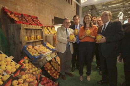 La consellera Serret, flanquejada per Ros i Reñé, ahir en un estand de fruites i conserves.