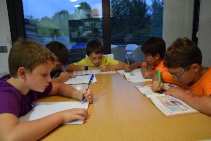Alumnes de primer d’ESO (a dalt) i de Primària (a baix) fent deures ahir.