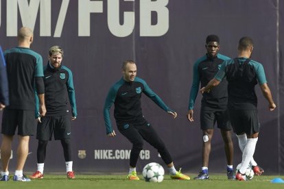 Iniesta, junto a otros jugadores, entre ellos Messi, durante el entrenamiento de ayer.