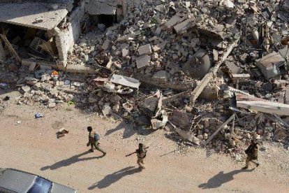 Soldats sirians caminen entre la runa a l’oest d’Alep.