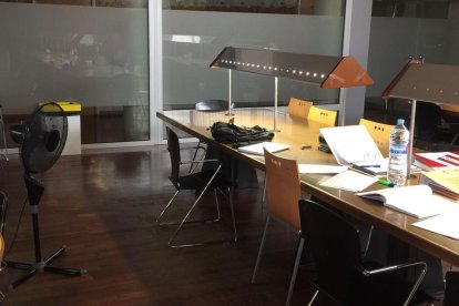 Un usuario de la sala, ayer por la tarde abanicándose con una hoja de papel para combatir el calor.