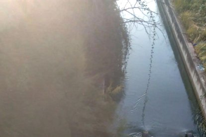 La grua amb el vehicle de les víctimes després de treure’l del canal a prop del lloc on van caure a l’aigua ahir a Bell-lloc.