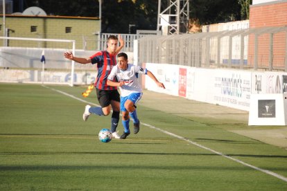 Una pugna entre dos futbolistes, ahir durant el partit al Municipal de Mollerussa.