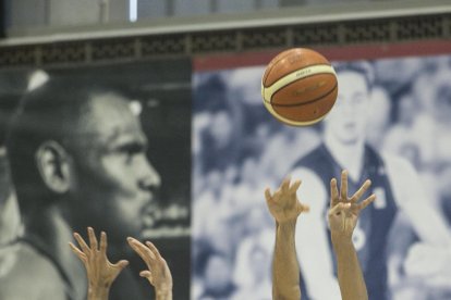 Juampi Sutina lanza a canasta ante la oposición de Figueras.